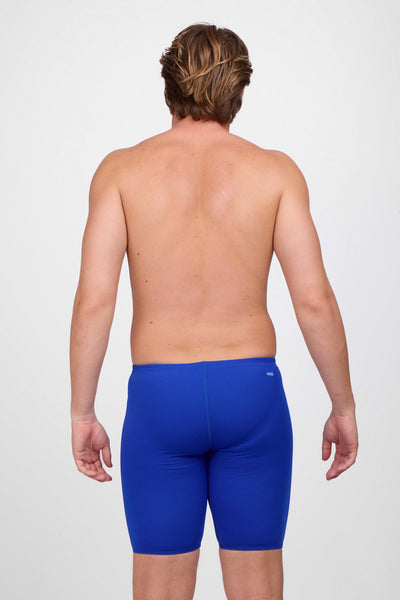 Male model wearing the Men's BROLYN Jammer in the Blueberry solid, standing in front of a grey background, shown from back view. 