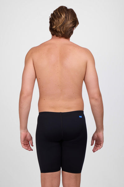 Male model wearing the Men's BROLYN Jammer in the Black solid, standing in front of a grey background, shown from back view. 