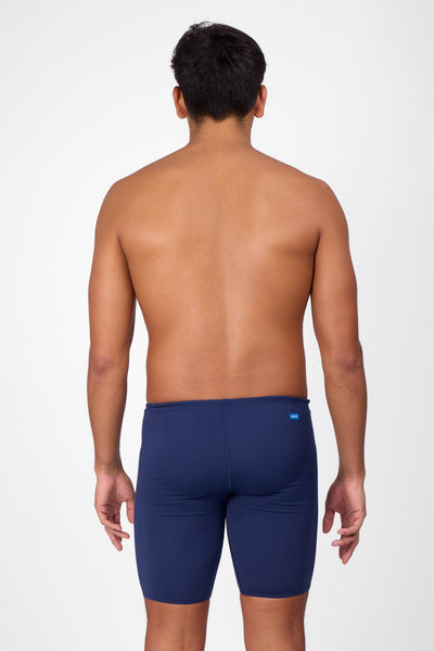 Male model wearing the Men's BROLYN Jammer in the Navy solid, standing in front of a grey background, shown from back view. 