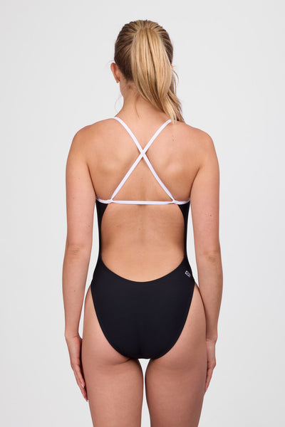 Female model wearing the Women's Brandon One Piece Swimsuit in the Black and White contrast, standing in front of a white background, shown from back view.