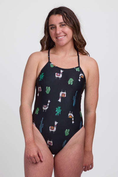 Female model wearing the Women's Jackson One Piece Swimsuit in the Llamarama print, standing in front of a grey background, shown from front view.