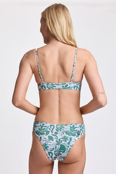 
Female model wearing the Women's Alanna Bikini Bottom in the Vista print, standing in front of a grey background, shown from back view.  