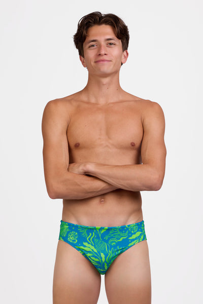 Male model wearing the Mens Brolyn Swim Brief in the Undersear print standing in front of a grey background, shown from the front view 

|| Size 32, Hips 29"  