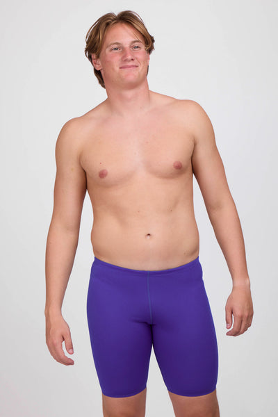 Male model wearing the Men's Brolyn Swim Jammer in the Purple solid, standing in front of a grey background shown from the front view