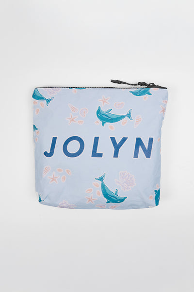 Up close image of the Dry Bag accessory in the Dolphrenz print, in front of a grey background, shown from the front view