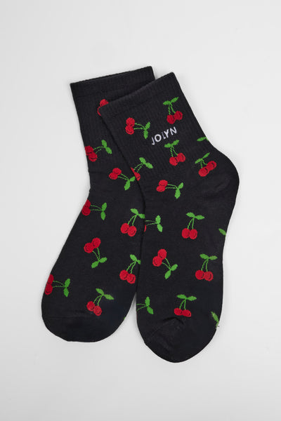 Up close image of the Unisex crew socks in the cherries print, in front  of a grey background, shown from the side view