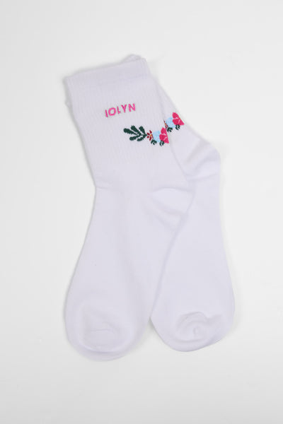Up close image of the Unisex crew socks in the Flower print, in front  of a grey background, shown from the side view