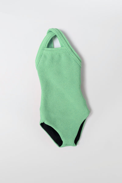 Flat Lay image of Mini Me Brandon Keychain in the Green Apple Solid, in front of a grey background, shown from the front view