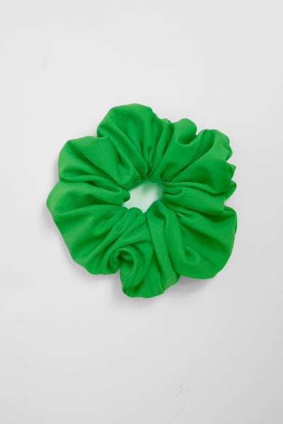 Up close image of the Scrunchie hair tie accessory in the Pothos solid, on top of a grey background, shown from the front view