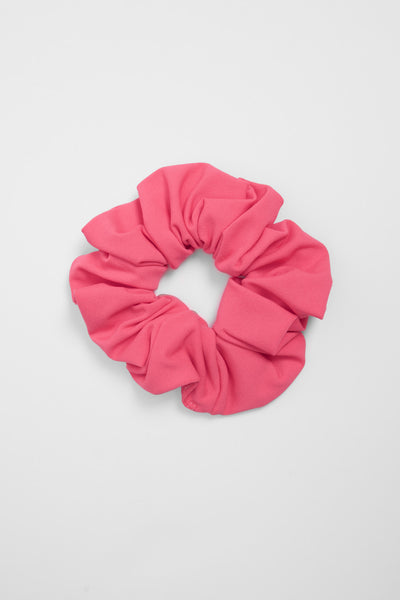 Up close image of the Scrunchie hair tie accessory in the Rose Finch solid, on top of a grey background, shown from the front view