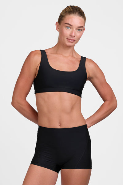 Female model wearing the Women's Anna Short in the Black solid, standing in front of a grey background shown from the front view 

|| Size S, Hip 37"