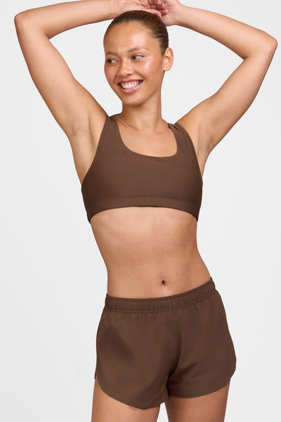 Female model wearing the Women's Chelsea Short in the Chocolate solid, standing in front of a grey background shown from the side view 

|| Size S, Hip 38"