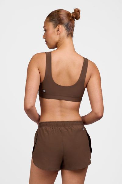 Female model wearing the Women's Chelsea Short in the Chocolate solid, standing in front of a grey background shown from the back view 

|| Size S, Hip 38"