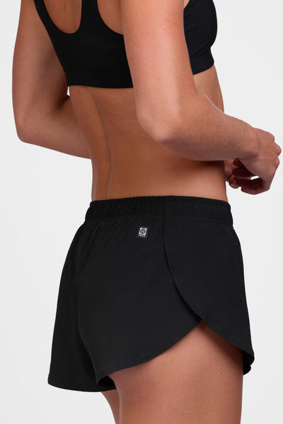 Female model wearing the Women's Lizzie Short in the Black solid, standing in front of a grey background shown from the side view 

|| Size S, Hip 37"