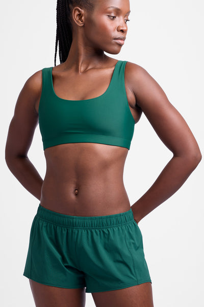 Female model wearing the Women's Rory Short in the Basil solid, standing in front of a grey background, shown from the front view.