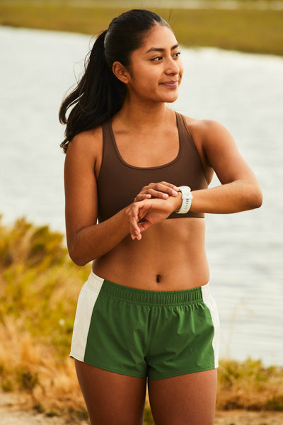 Female model wearing the Women's Rory Short in the Mountain Mist contrast, standing in front of a green background shown from the front view 

|| Size S, Hip 37"