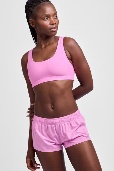 Female model wearing the Women's Rory Short in the Pinky solid, standing in front of a grey background, shown from the front view.