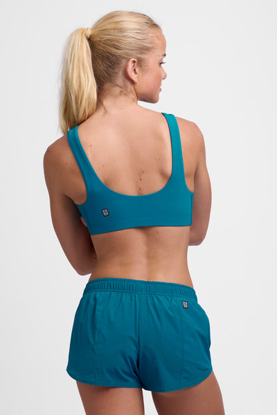 Female model wearing the Women's Rory Short in the Spacesolid, standing in front of a grey background, shown from the back view.