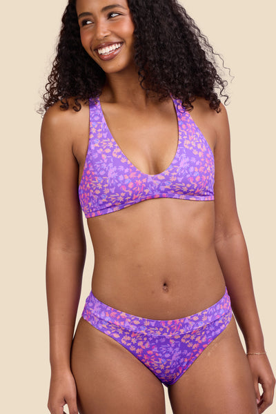 Female model wearing the Women's Alanna Bikini Bottom in the Jellybean print, standing in front of a yellow background shown from the front view

|| Size S, Hips 37"