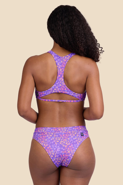 Female model wearing the Women's Alanna Bikini Bottom in the Jellybean print, standing in front of a yellow background shown from the back view

|| Size S, Hips 37"