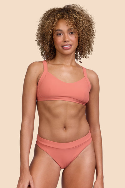 Female model wearing the Women's Alanna Bikini Bottom in the Serrano Ribbed solid, standing in front of a yellow background, shown from the front view

|| Size S, Hip 36" 