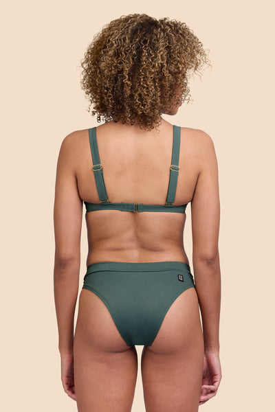 Female model wearing the Womens Alanna Bikini Bottom in the Zucchini solid, standing in front of a yellow background shown from the back view

|| Size S, Hip 36"  