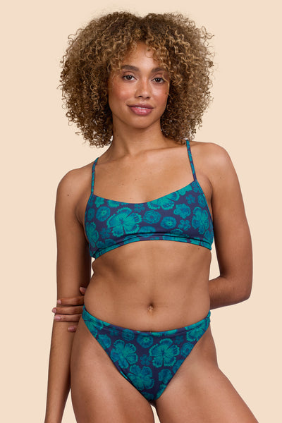 Female model wearing the Women's Ava Bikini Bottom in the Moon Flower print, standing in front of a yellow background, shown from the front view

|| Size S, Hip 36"