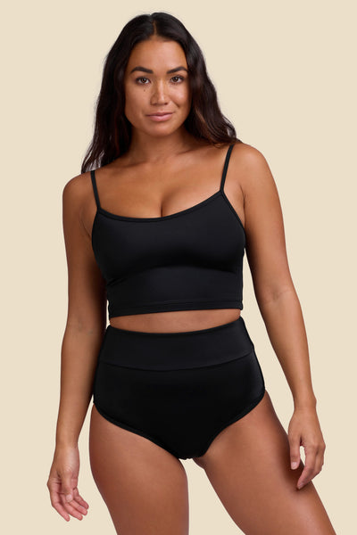 Female model wearing the Women's Aveline Bikini Bottom in the Black solid, standing in front of a yellow background shown from the front view

|| Size S, Hips 35"  
