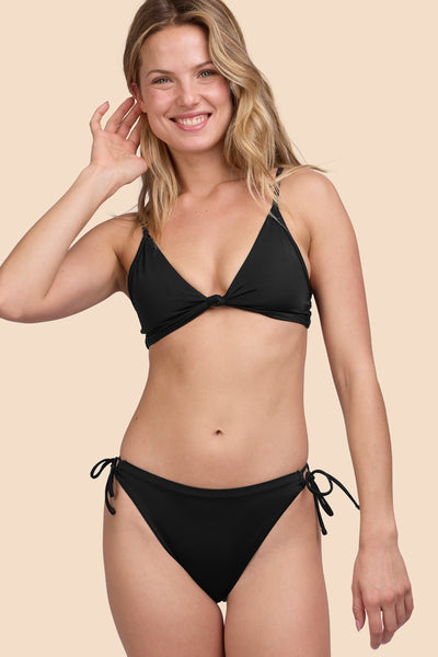 Female model wearing the Womens Bella Bikini Bottom in the Black solid, standing in front of a yellow background shown from the front view

|| Size S, Hip 36"  