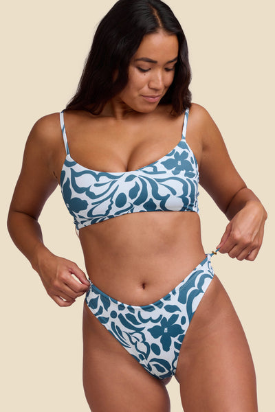 Female model wearing the Women's Ciara Bikini Bottom in the Sumatra print, standing in front of a yellow background shown from the front view

|| Size S, Hips 35"  
