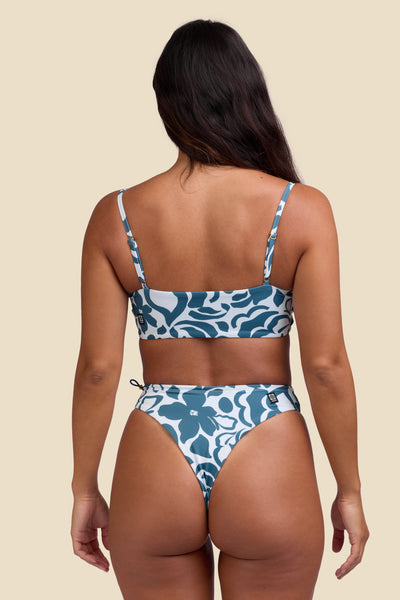 Female model wearing the Women's Ciara Bikini Bottom in the Sumatra print, standing in front of a yellow background shown from the back view

|| Size S, Hips 35"  