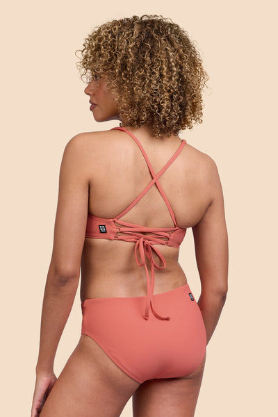Female model wearing the Women's Dakota Bikini Bottom in the Serrano Ribbed solid, standing in front of a yellow background, shown from the side view

|| Size S, Hip 36" 