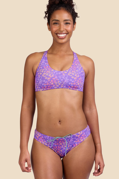 Female model wearing the Women's Gina Bikini Bottom in the Jellybean print, standing in front of a yellow background shown from the front view

|| Size S, Hips 37"
