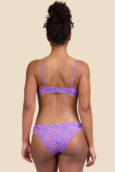 Female model wearing the Women's Gina Bikini Bottom in the Jellybean print, standing in front of a yellow background shown from the back view

|| Size S, Hips 37"
