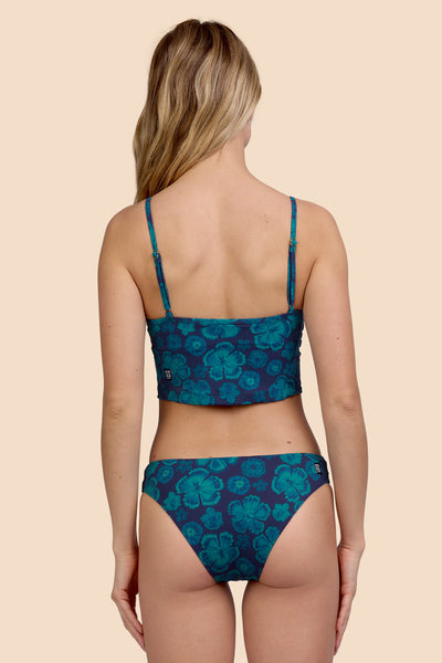 Female model wearing the Women's Gina Bikini Bottom in the Moon Flower print, standing in front of a yellow background, shown from the back view

|| Size S, Hip 36"