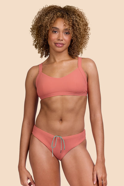 Female model wearing the Women's Gina Bikini Bottom in the Serrano Ribbed solid, standing in front of a yellow background, shown from the front view

|| Size S, Hip 36" 