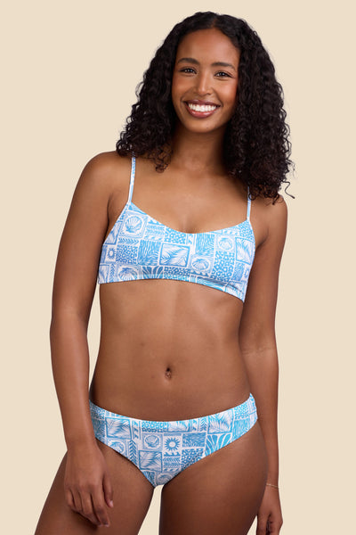 Female model wearing the Women's Gina Bikini Bottom in the Swell print, standing in front of a yellow background shown from the front view

|| Size S, Hips 37" 