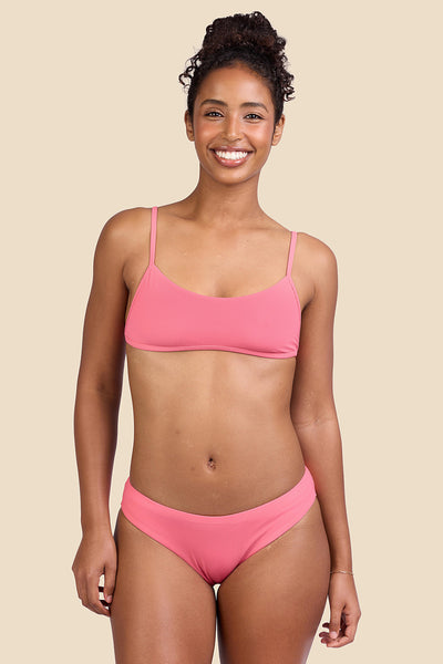 Female model wearing the Women's Gina Bikini Bottom in the Tea Rose Ribbed solid, standing in front of a yellow background shown from the front view

|| Size S, Hips 37"  