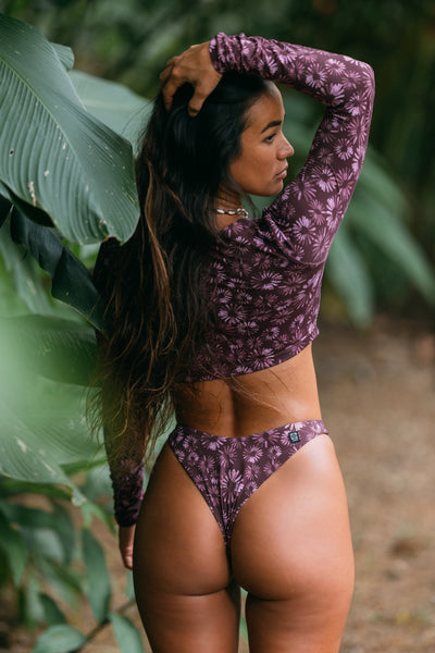 Female model wearing the Women's Jessica Bikini Bottom in the Bondi Blossom print, standing in front of a beach shown from the back view

|| Size S, Hips 35"  