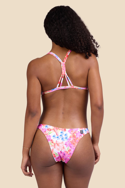 Female model wearing the Women's Kelia Bikini Bottom in the Orchids Ribbed print, standing in front of a yellow background shown from the back view

|| Size S, Hips 37" 