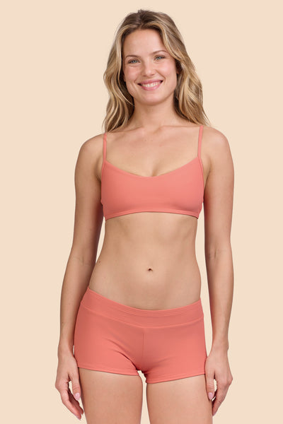 Female model wearing the Women's Piha Surf Short in the Serrano Ribbed solid, standing in front of a yellow background, shown from the front view

|| Size S, Hip 36" 