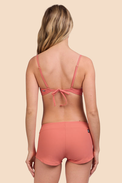Female model wearing the Women's Piha Surf Short in the Serrano Ribbed solid, standing in front of a yellow background, shown from the back view

|| Size S, Hip 36" 