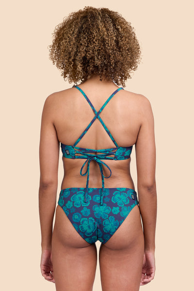 Female model wearing the Women's Valle Bikini Bottom in the Moon Flower print, standing in front of a yellow background, shown from the back view

|| Size S, Hip 36"