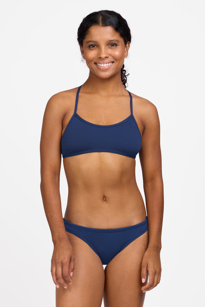Female model wearing the Women's Europe Bikini Bottom in the Navy solid, standing in front of a grey background shown from the front view

|| Size S, Hips 36.5"