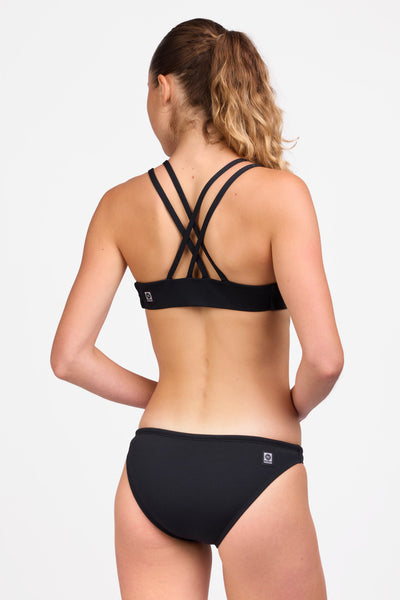 Female model wearing the Women's Midl Bikini Bottom in the Black solid, standing in front of a grey background shown from the back view

|| Size S, Hips 35"