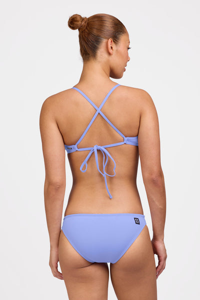 Female model wearing the Women's Midl Bikini Bottom in the Lavender solid, standing in front of a grey background shown from the back view

|| Size M, Hips 38"