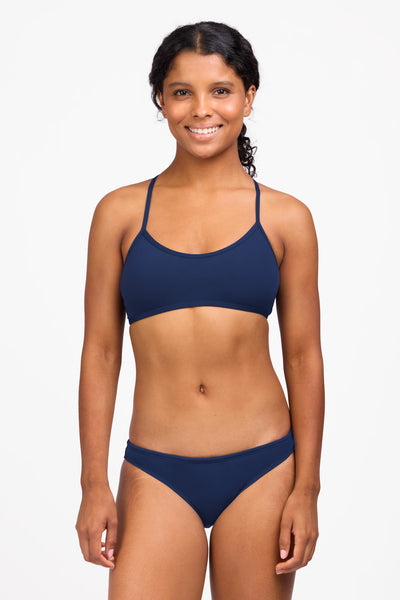 Female model wearing the Women's Midl Bikini Bottom in the Navy solid, standing in front of a grey background shown from the front view

|| Size S, Hips 36.5"