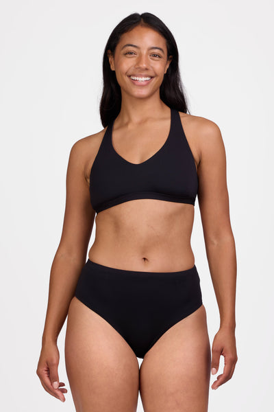 Female model wearing the Women's Sandra Bikini Bottom in the Black solid, standing in front of a grey background shown from the front view


|| Size M, Hips 40"