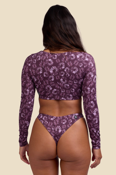 Female model wearing the Women's Avalon Rashguard in the Bondi Blossom print, standing in front of a yellow background shown from the back view

|| Size S, Bust 34"  