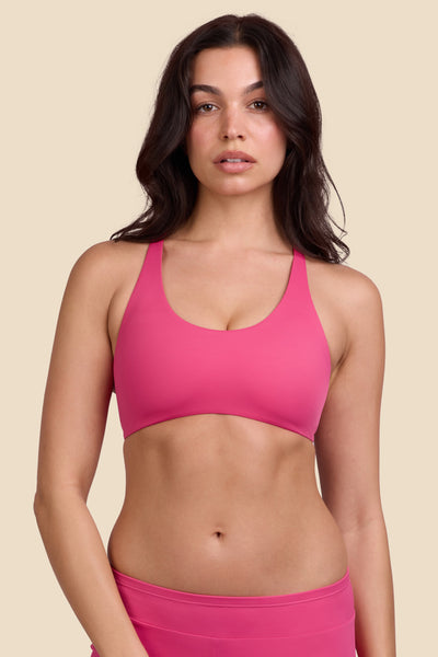 Female model wearing the Women's Blake Bikini Top in the Berry solid, standing in front of a yellow background shown from the front view

|| Size M, Bust 32"  
